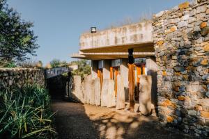 a stone building with orange doors and a stone wall at Forum Homini Boutique Hotel in Krugersdorp +58 photos