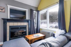 a living room with a couch and a fireplace at Sunshine Summit Ski-In-Out Pool Shuttle in Blue Mountains