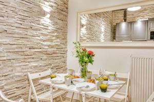a dining room with a white table with flowers on it at Saroko Apartment 1 in Ágios Rókkos