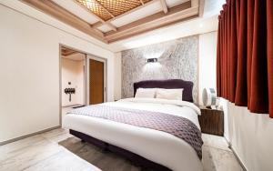 首尔Jardin Hotel的房间里有一张大床的卧室