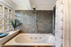 une baignoire blanche dans une salle de bain avec une fenêtre dans l'établissement Hüs Swarte Wall, à Kampen 17 autres photos