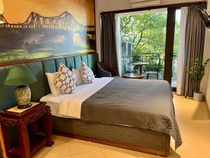 a bedroom with a bed with a painting on the wall at Hanoi Street Hotel in Hanoi +65 photos