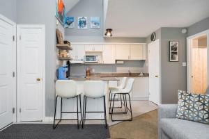 une cuisine avec une table et des tabourets blancs dans l'établissement Blue Haven Ski-In-Out Pool Hot Tub Shuttle, à Blue Mountains