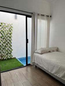 Un dormitorio con una cama y una puerta corrediza de vidrio. en Departamento Grace, moderno y centrico con Netflix, en Campeche