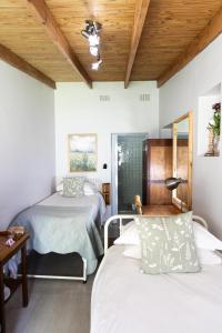 a bedroom with two beds and a wooden ceiling at LA Guesthouse in Piet Retief