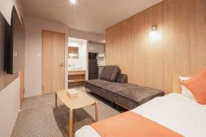 una habitación de hotel con una cama y una silla en グランドベースMirai, en Nagasaki