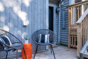 eine Terrasse mit 2 Stühlen und einem Tisch mit einer Vase in der Unterkunft Fox Ridge - Ski-In-Out Pool Hot Tub Shuttle in Blue Mountains