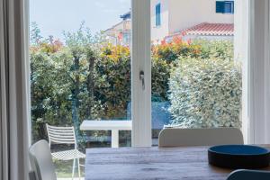 a table and chairs in front of a sliding glass door at Residence with panoramic swimming pool in Porto San Paolo just 850 mt from the sea in Porto San Paolo