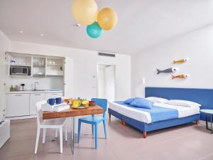 a bedroom with a bed and a table and a kitchen at Residence with panoramic swimming pool in Porto San Paolo just 850 mt from the sea in Porto San Paolo