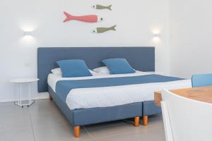 a bedroom with a blue bed with two fish on the wall at Residence with panoramic swimming pool in Porto San Paolo just 850 mt from the sea in Porto San Paolo +28 photos