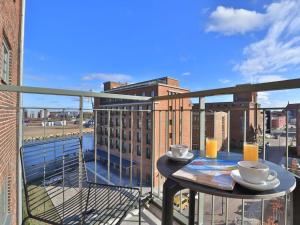 balkon ze stolikiem, dwoma kubkami i napojami w obiekcie Ohlerich Speicher App_ 29 w mieście Wismar