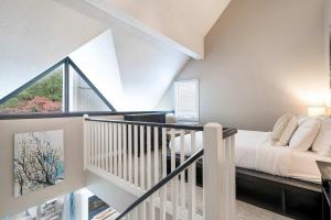 a white bedroom with a bed and a balcony at Whispering Pines - Ski-In-Ou Pool Shuttle in Blue Mountains