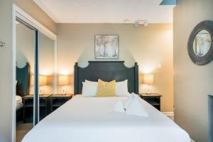 a bedroom with a large white bed and two lamps at Whispering Pines - Ski-In-Ou Pool Shuttle in Blue Mountains +38 photos