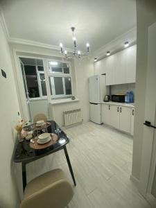 Квартира посуточно في أستانا: مطبخ مع طاولة وثلاجة