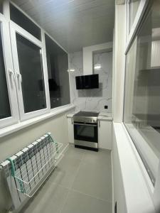 Квартира посуточно في أستانا: مطبخ ابيض مع موقد ونافذة +3 صور