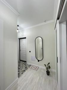 Квартира посуточно في أستانا: ممر مع مرآة على الحائط وباب