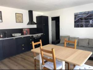 a kitchen and living room with a wooden table and chairs at Gîte soline avec piscine chauffée in Saint-Riquier