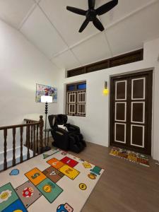 New ! 6 Pax Super Mario Georgetown Heritage Pre-war House 2 Bedroom في جورج تاون: غرفة معيشة مع مروحة سقف وسجادة