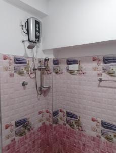 a shower in a bathroom with pink tile at Akshaya Guest Inn Kandy in Kandy +35 photos