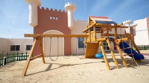 een speeltuin met een glijbaan en een speelstructuur bij Oyster Bay Beach Suites in Marsa Alam