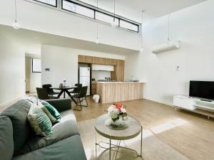 库克角Skyline Loft I HERstay in Point Cook的客厅里有一张沙发和一张桌子。