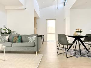 库克角Skyline Loft I HERstay in Point Cook的带沙发、桌子和椅子的客厅