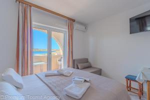 ein Schlafzimmer mit einem Bett mit Blick auf das Meer in der Unterkunft Katarina 1 in Zubovići
