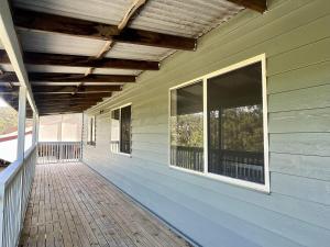an empty porch of a house with windows at Cocora Beach Cottage - pet friendly in Eden