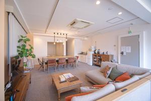 a living room with a couch and a table at INOVE VILLA Osaka in Osaka