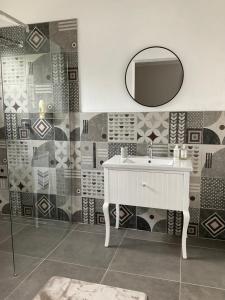 a bathroom with a white sink and a mirror at Ginnys Place in Gaborone