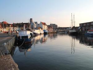 un gruppo di imbarcazioni è ormeggiato in un fiume di Ohlerich Speicher App_ 12 a Wismar