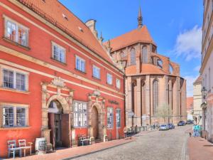 un edificio in mattoni rossi con una chiesa e una strada di Ohlerich Speicher App_ 12 a Wismar Altre 20 foto