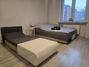 a bedroom with two beds and a window at Apartament Tuwima 2 in Zabrze