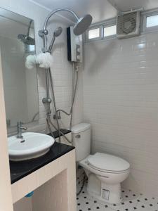 a white bathroom with a toilet and a sink at T-home Maerim in Bān Thung Phuang