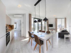 kuchnia i salon z białym stołem i krzesłami w obiekcie Ohlerich Speicher App 43 w mieście Wismar