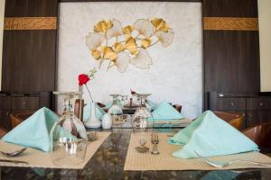 a dining room table with a table set with blue napkins at Oyster Bay Beach Suites in Marsa Alam