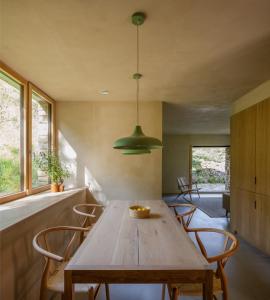 a dining room with a wooden table and chairs at Casa Mínima retiro Passivhaus in Selaya