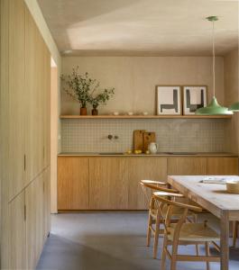 a kitchen with a table and chairs in a room at Casa Mínima retiro Passivhaus in Selaya