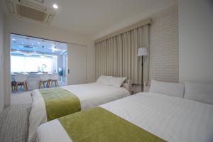 a hotel room with two beds and a dining area at INOVE VILLA OSAKA -120m2 , 7 Double Beds , 2 BR , 2 Bath , Easy Access to Umeda , Kyoto ーPerfect for Families & Groupsー in Osaka +58 photos