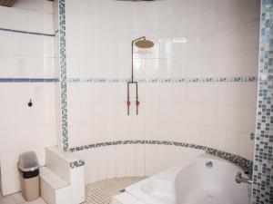a bathroom with a tub and a toilet and a sink at Bluewater Guesthouse in Port Elizabeth +98 photos