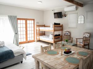 a living room with a bed and a table and a bunk bed at Bluewater Guesthouse in Port Elizabeth
