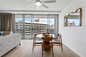 un soggiorno con tavolo e sedie e una grande finestra di Marina Vista - Waterfront Stay near Dining and Markets a Cairns