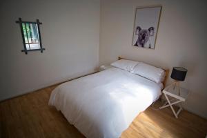 Goolwa SouthDelight On Downer - Coastal Family Escape的卧室配有一张白色床,墙上挂着一幅画