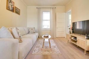 三河城Séjour zen au Bor de l'eau的客厅里有一张白色沙发和一台电视