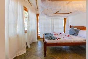a bedroom with a canopy bed with white curtains at Silver Residence Apartments by MOKAWA in Malindi +61 photos