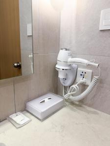 uma casa de banho com um WC branco e um telefone em City Garden Hotel Makati em Manilla
