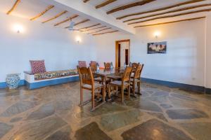 a dining room with a wooden table and chairs at Silver Residence Apartments by MOKAWA in Malindi