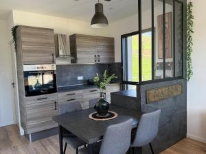 a kitchen with a table with a vase of flowers on it at Studio cosy au Crêt du Chardon in Chambost-Allières