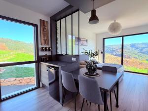 a kitchen with a table and a dining room with a view at Studio cosy au Crêt du Chardon in Chambost-Allières