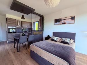 a bedroom with a bed and a dining room at Studio cosy au Crêt du Chardon in Chambost-Allières